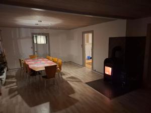 ein Esszimmer mit Tisch und Stühlen sowie einem Kamin in der Unterkunft kærgård in Bøvlingbjerg