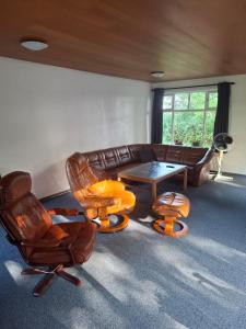ein Wohnzimmer mit Sofa, Stühlen und einem Tisch in der Unterkunft kærgård in Bøvlingbjerg
