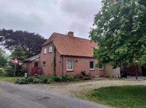 ein Backsteinhaus mit einem Baum davor in der Unterkunft kærgård in Bøvlingbjerg