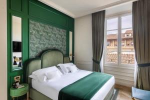 a green bedroom with a bed and a window at Hotel La Gemma in Florence +81 photos