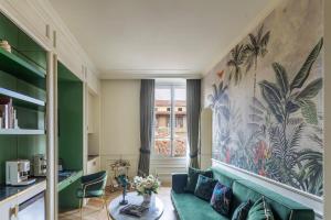 a living room with a green couch and a wall mural at Hotel La Gemma in Florence