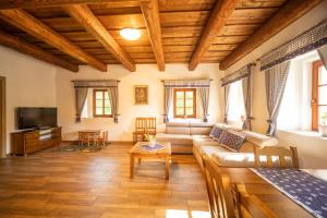 a living room with a couch and a tv at Ubytování pod Dubem in Broumov