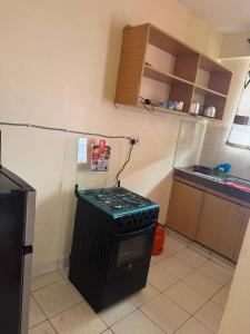 a kitchen with a stove top oven in a room at Sunrise Suites EMBU in Embu