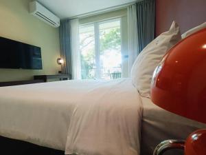 a bedroom with a large bed with a large window at Syama Mansion Kamala in Kamala Beach