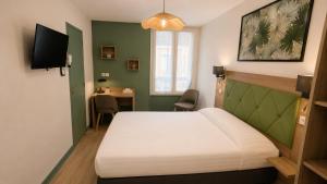 a bedroom with a bed and a desk in it at Logis Hôtel Au Croissant in Buzançais