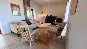 a living room with a couch and a table and chairs at Urla Sunrise House in Ildır