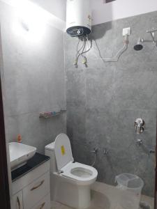 a bathroom with a white toilet and a sink at Naresh Guest House in Sonprayag
