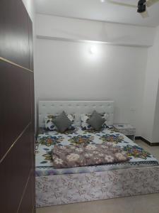 a bedroom with a bed with a floral bedspread at Naresh Guest House in Sonprayag