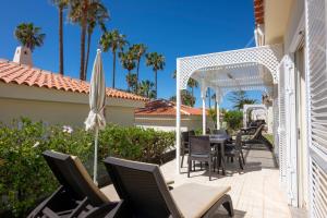 a patio with a table and chairs and an arbor at Ona Sueño Azul in Callao Salvaje