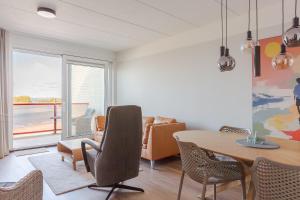 a dining room with a table and chairs with a view at Zuiderzee State - Appartementen in Makkum