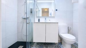 a white bathroom with a toilet and a shower at Logis Hôtel Au Croissant in Buzançais +38 photos