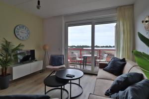 a living room with a couch and a table at Zuiderzee State - Appartementen in Makkum +20 photos