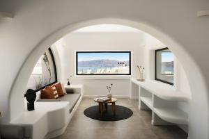 an archway in a living room with a couch and a table at The Duchess in Therasia