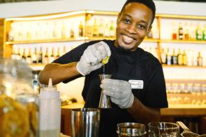 a man is making a drink in a bartender at Pongwe Beach Hotel in Pongwe