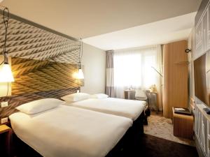 a hotel room with two beds and a window at ibis Lyon Carre De Soie in Vaulx-en-Velin +148 photos
