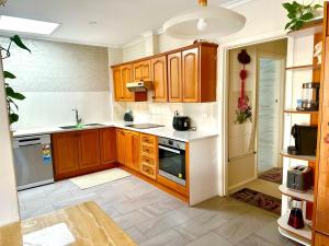 a kitchen with wooden cabinets and a stove top oven at Jalynn homestay in Glen Waverley