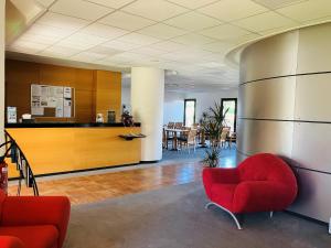 an office lobby with red chairs and a counter at Résidence Des Équipages in Le Castellet