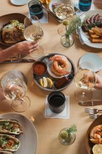 a table with plates of food and glasses of wine at Dune House Hotel & Spa in Atlantic Beach
