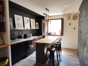 a kitchen with a wooden table and some chairs at Logement cosy Sous Les Toits in Charmes-sur-Rhône