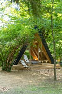 a house with a chair in the middle of a forest at Youth Hostel Proteus Postojna in Postojna