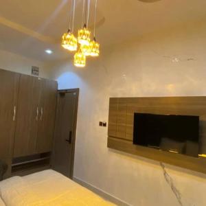 a bedroom with a bed and a flat screen tv at Laycon hotel and suites in Ikuata