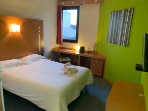 a bedroom with a bed and a desk and a window at Résidence Des Équipages in Le Castellet