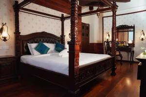 a bedroom with two canopy beds with white sheets at JC Residency Madurai in Madurai