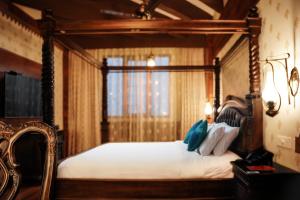 a bedroom with a canopy bed with a window at JC Residency Madurai in Madurai