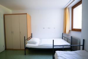 a bedroom with two bunk beds and a window at Youth Hostel Proteus Postojna in Postojna +38 photos