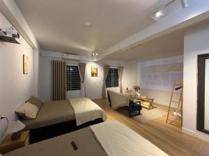a bedroom with two beds and a table and a desk at 12 Homestay & Hotel in Lạng Sơn