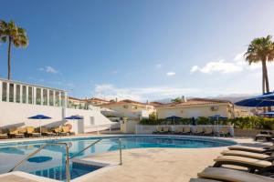 a swimming pool with chairs and umbrellas in a resort at Ona Sueño Azul in Callao Salvaje