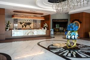 a lobby with a reception area with blue flowers on a table at Tripolis Hotel in Pamukkale +52 photos