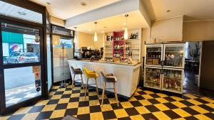 a restaurant with a bar with yellow stools at Logis Hôtel Au Croissant in Buzançais