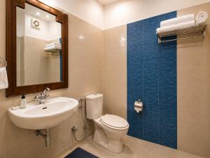 a bathroom with a toilet and a sink and a mirror at Swaasha Vista in Kausani