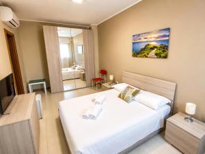 Grab a Flat in Coroneo في ترييستي: غرفة نوم بها سرير أبيض كبير وجهاز تلفزيون