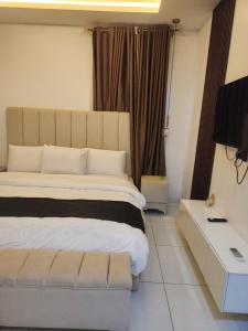 a bedroom with a large bed and a television at De Atrium apartment in Galadima