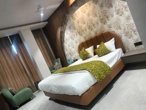a bedroom with a large bed with a padded headboard at Mayur baag resort in Sāgar