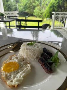 a plate of food with eggs and bacon on a table at Cazabela in Casisang