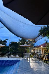 a person sitting at a table next to a pool at Cazabela in Casisang