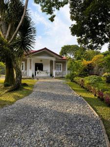 a gravel driveway leading to a white house at Cazabela in Casisang