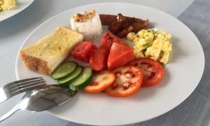 a plate of breakfast food with eggs tomatoes and toast at Lion Dive Resort in Moalboal +19 photos