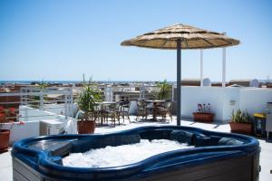 a hot tub on a balcony with an umbrella at Bohemia palace in Hurghada