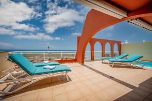 a balcony with chairs and a view of the ocean at Villa Afreen Playa in Morro del Jable