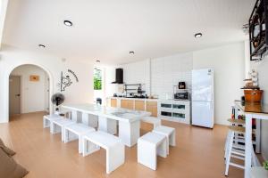a white kitchen with a white table and white appliances at Seahorse poolvilla sattahip SP2 in Ban Nong Sa