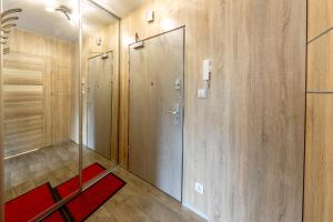 a walk in shower with a glass door and a red rug at Apartament Eva in Karpacz