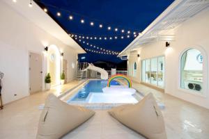 a pool with a rainbow in the middle of a house at Seahorse poolvilla sattahip SP2 in Ban Nong Sa
