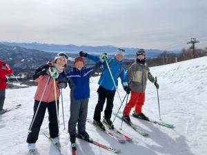 a group of people on skis on a snow covered slope at Myoko Mountain Lodge in Myoko