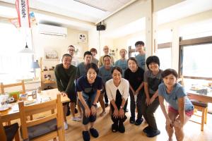 a group of people posing for a picture in a room at Myoko Mountain Lodge in Myoko
