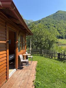 a cabin with a table and a bench on a deck at Bujtina Lepushe Agroturizem in Lëpushë