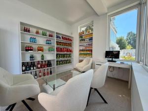 a home office with white chairs and a desk and a window at ROYAL PARK Complex in Bascov